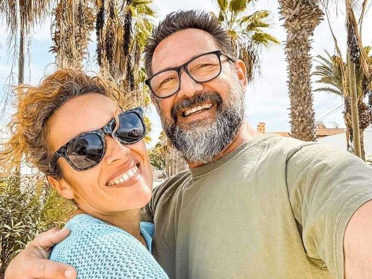 Two Adults Smiling Outdoors After Undergoing Implant-Supported Denture Treatment in Mesa, AZ