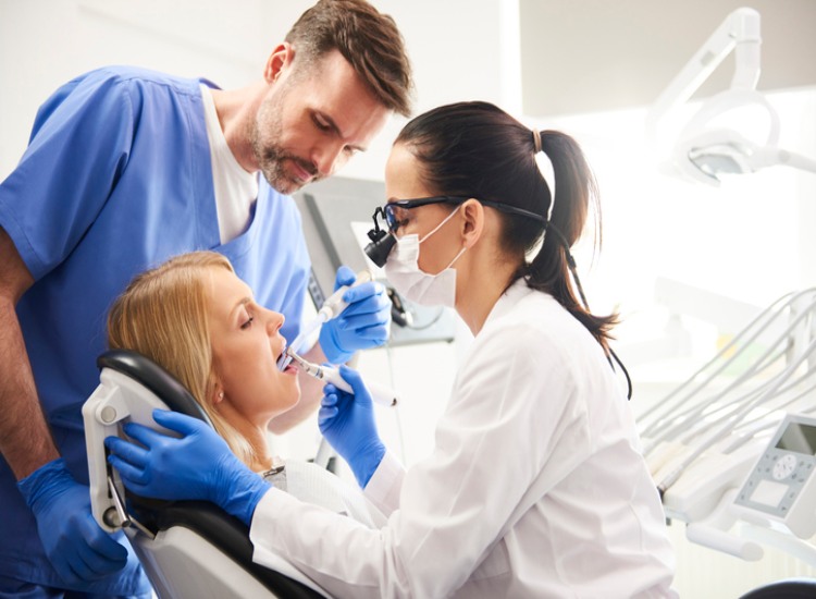 The dentist and her assistant examining a patient’s teeth at Restoration Dental in Mesa, AZ.