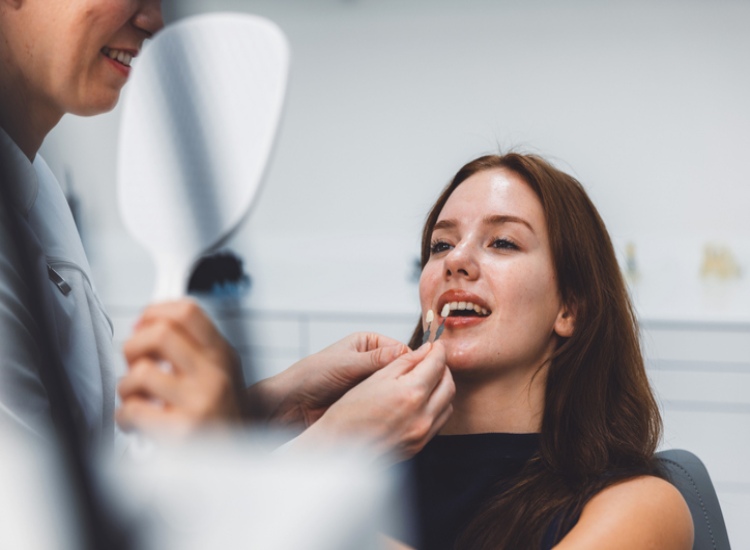 A Restoration dental professional fitting a dental veneer in Mesa, AZ